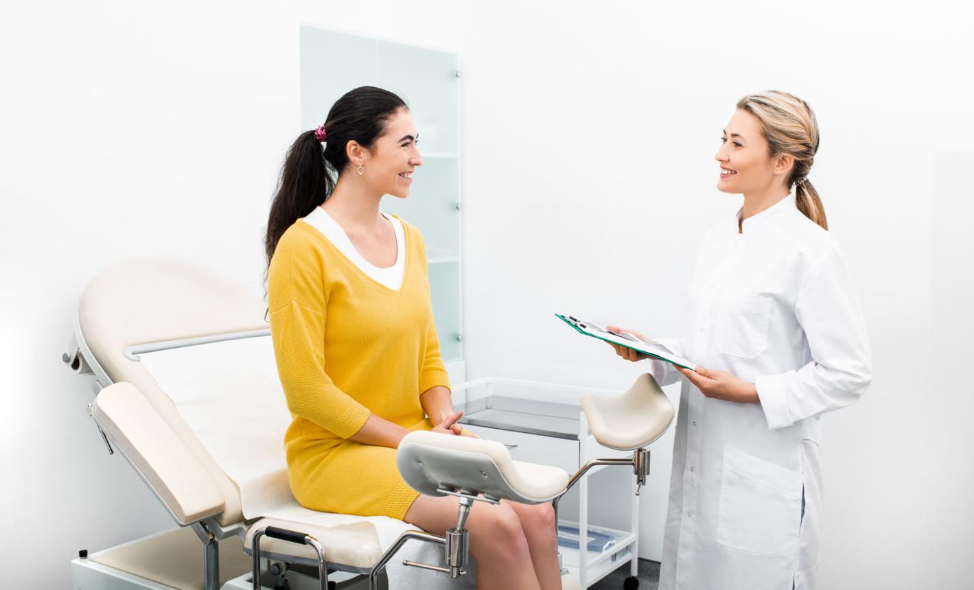 Patient sitting in a gynecological chair during a consultation with her attending gynecologist in a modern clinic. Women's health, uterus